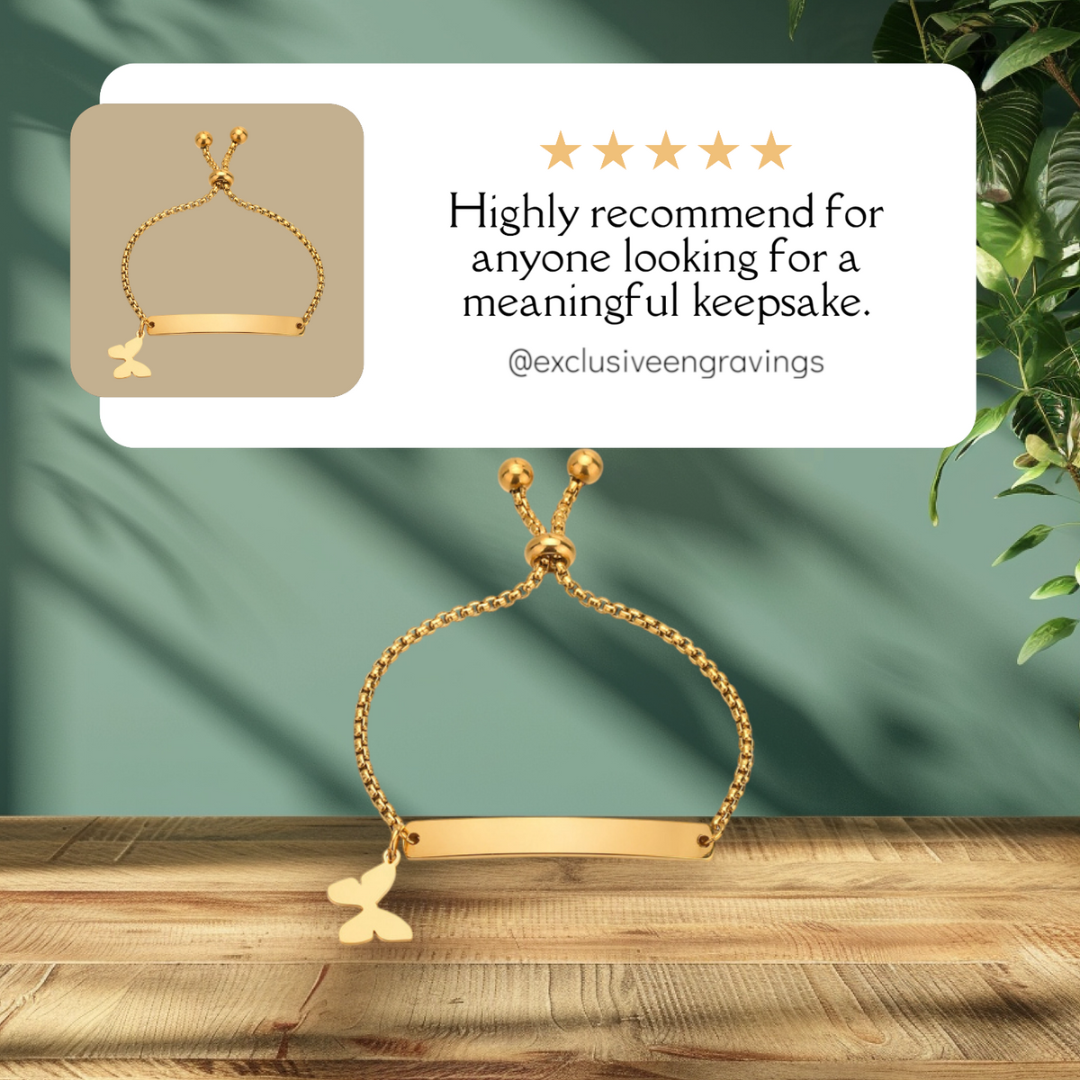 Gold bracelet with butterfly charm on a wooden surface with a green fabric background